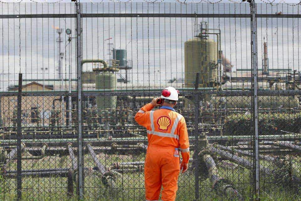 A worker is watching the facility operation conditions in the oil field enclosed by 358 high security fence.