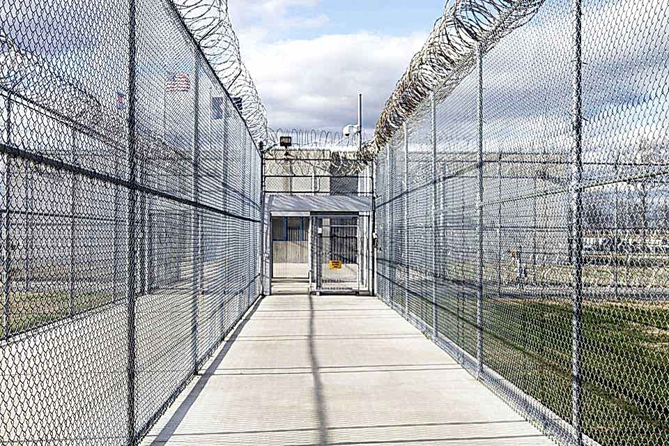 Chain link fence with a concertina topping is installed along the prison.