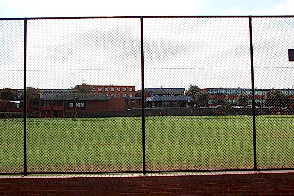 Chain link fences are installed along the sports field.