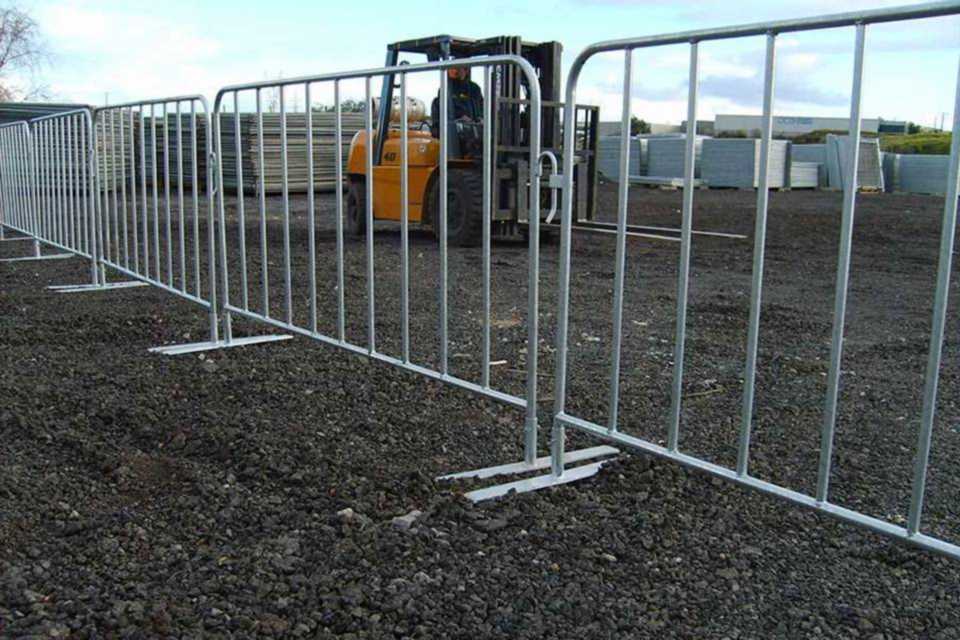 A driver is driving a forklift in the construction area enclosed by crowd control barrier.