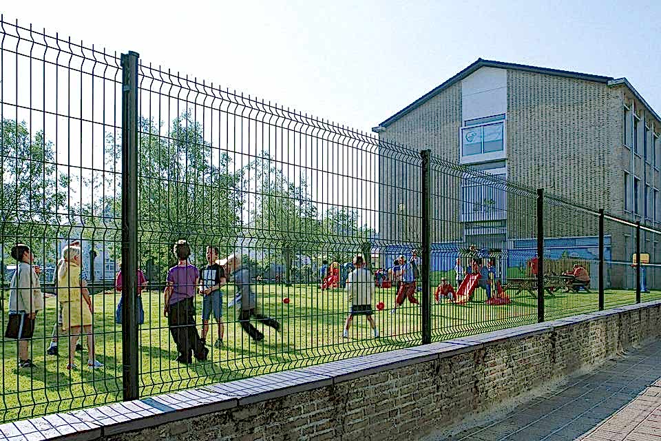 Several kids are playing in the playground encircled by curvy welded fence.