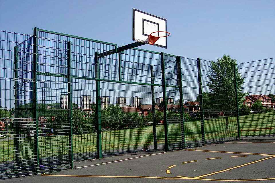 Double wire fences are installed around a basketball court.