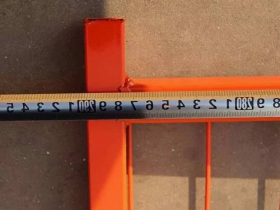 A man is measuring the length of Canada temporary fence.