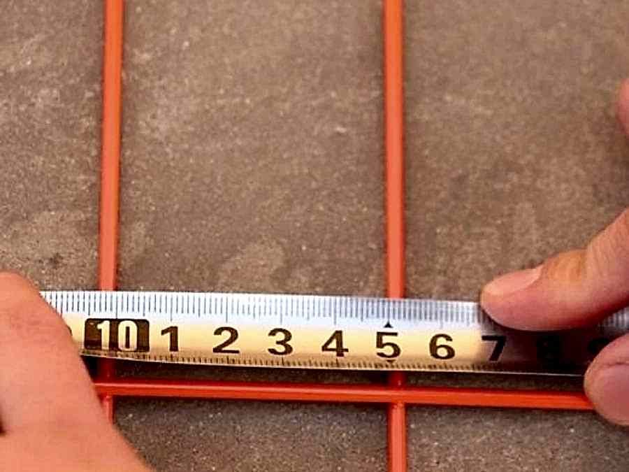 A man is measuring the mesh size of Canada temporary fence.