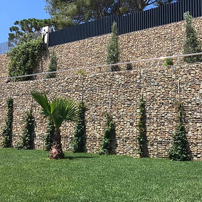 Welded gabions are installed as the exterior wall of the house.