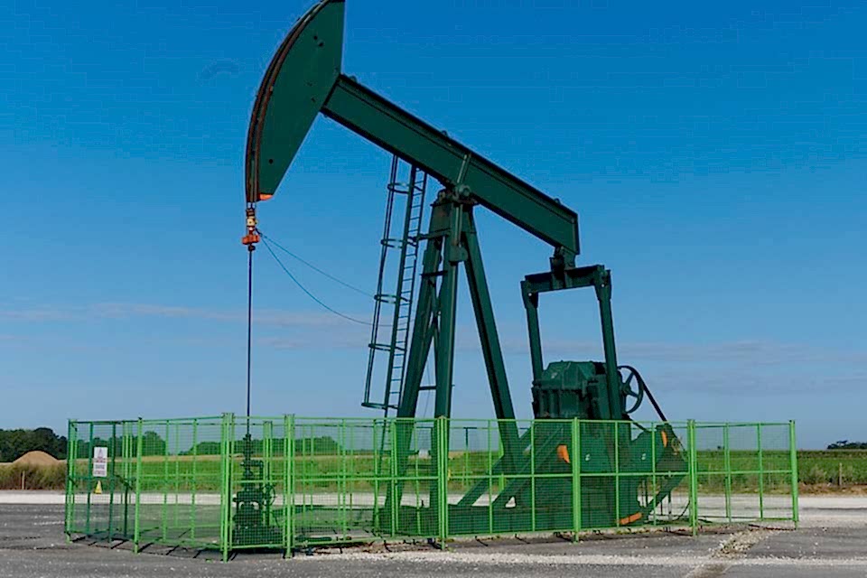 A set of oil developing machine is parking in the oil field fence made of welded wire mesh panels.